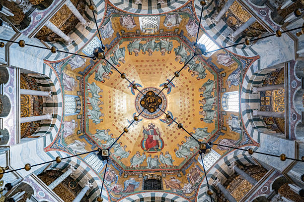 A detailed view of the painted ceiling in Aachen Cathedral, showcasing vibrant religious artwork and historical Christian symbolism.