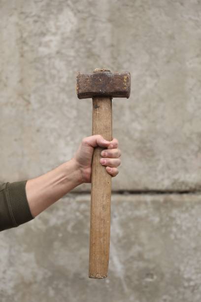 istock Man with sledgehammer near grey wall, closeup 2202971000