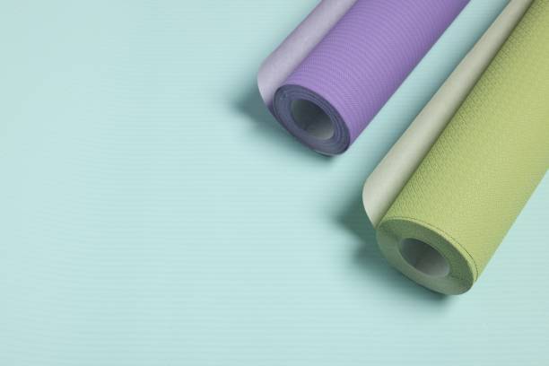 istock Two colorful wallpaper rolls on light turquoise sample, above view. Space for text 2202972264