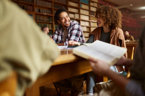 istock Diverse college couple studying together in library. 2202978177