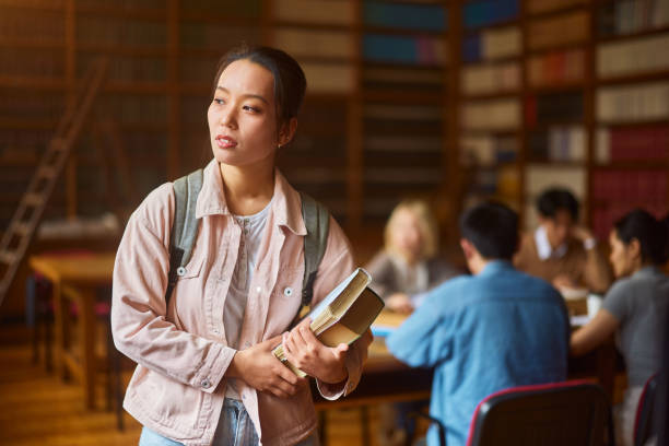 istock Pensive Asian female student in library. 2202979226