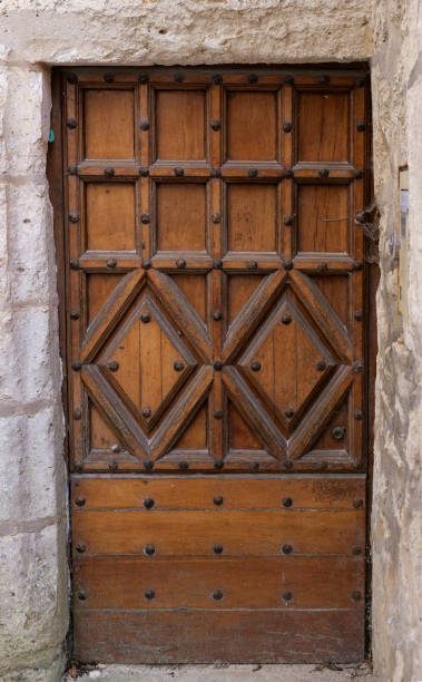 istock A wooden door with a stone frame and a stone wall behind it 2202979351