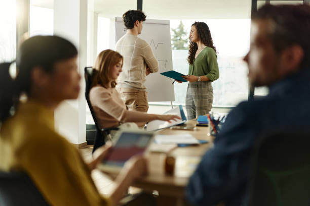 istock Happy colleagues talking in front of whiteboard at casual office. 2202980969