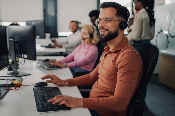 istock Male call center agent working on computer in busy office 2202982618