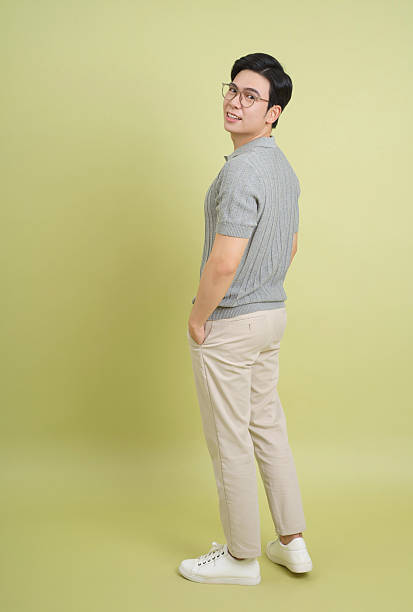 istock Young man in casual attire poses confidently against a light green background 2202984302