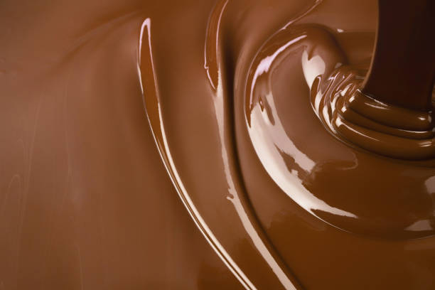 istock hot melted chocolate background, splash of liquid cocoa 2202988181