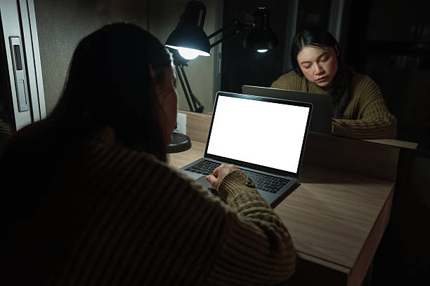 istock sleepy woman working with laptop at night (with clipping path) 2202988361