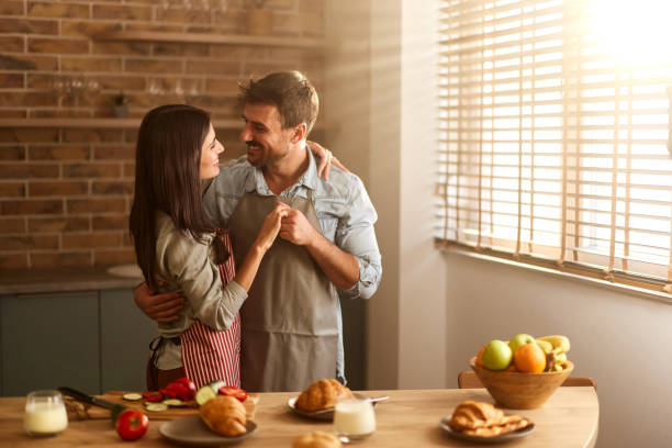 istock Happy couple in love talking in the kitchen. 2202989383