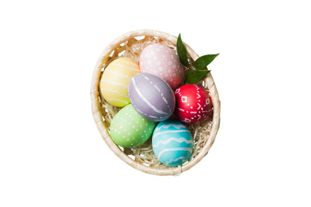 istock Basket of colorful Easter eggs isolated on white background. Easter basket filled with colored eggs top view holiday concept 2202989496