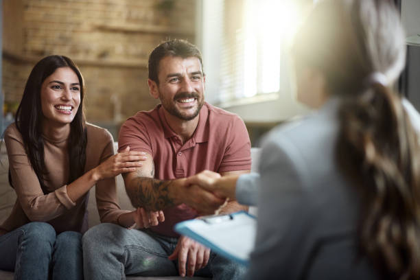 istock Happy couple shaking hands with their advisor at home. 2202989887