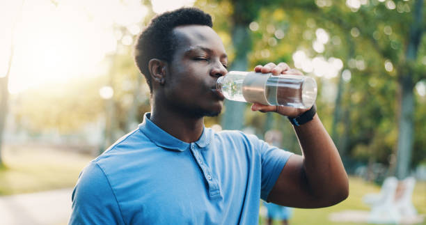 istock Fitness, exercise and black man with drinking water at park for workout break, hydration and thirsty from running. Detox, runner and liquid bottle for refresh, cardio recovery and training in nature 2202993801