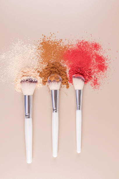istock Top vertical view of three makeup brushes with samples of loose makeup textures. Beige background. makeup brush. Beauty concept. cosmetic background. 2202994856
