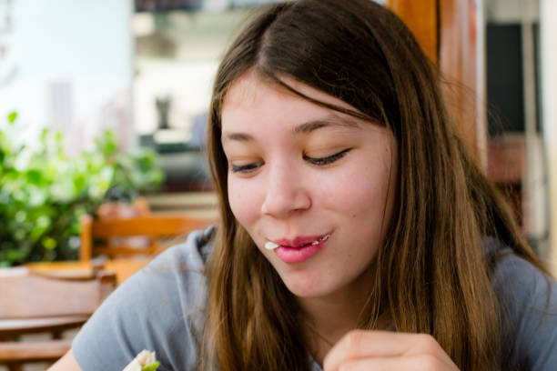 Teenage girl eating in a fast food restaurant.