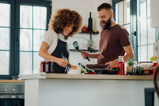 istock Happy couple cooking together in modern kitchen 2202995289