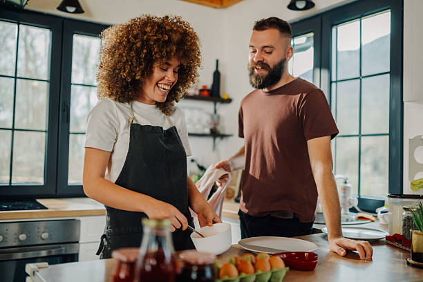 istock Happy couple preparing food and having fun in kitchen 2202995302