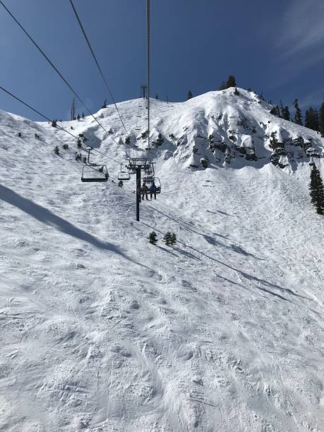 istock Ski lift on a snowy mountain under clear blue sky. 2202997172