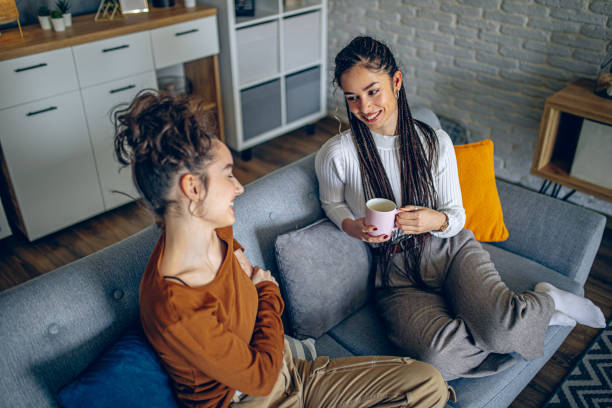 istock Two roommates are having a conversation in the living room 2202998266
