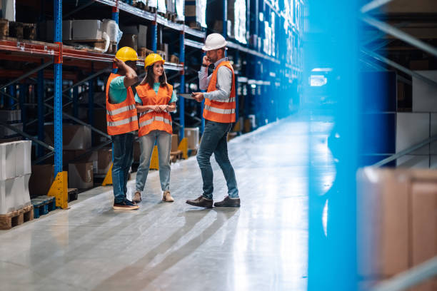 istock Warehouse workers discussing logistics while manager is talking on the phone 2203001445