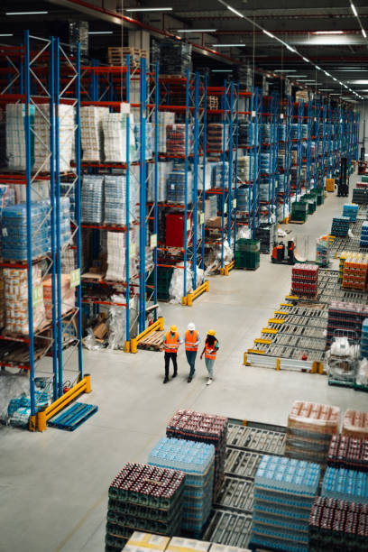 istock Warehouse workers walking and controlling inventory in large distribution center 2203001462