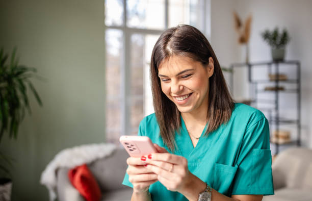 istock Young female nurse smiles while using a smartphone in a modern medical office environment 2203002254