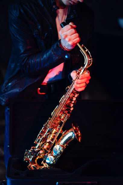 istock Young saxophonist preparing his saxophone before a jam session 2203003053