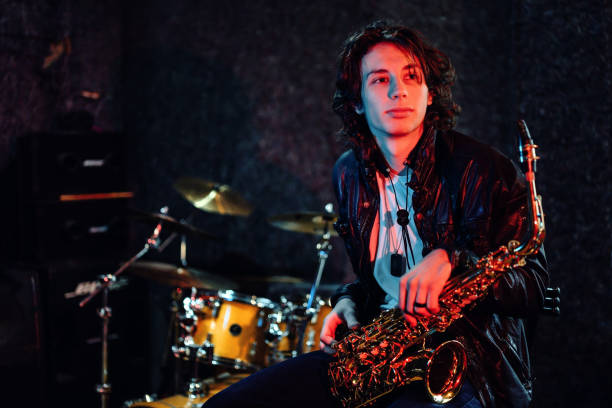 Portrait of a young saxophone player in a recording studio