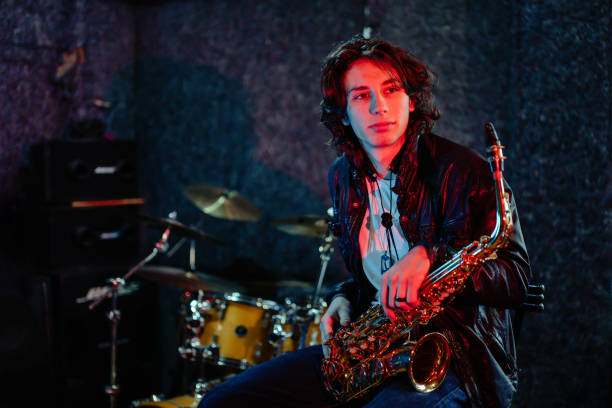 Portrait of a young saxophone player in a recording studio