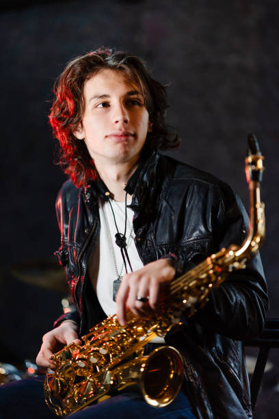 Portrait of a young saxophone player in a recording studio