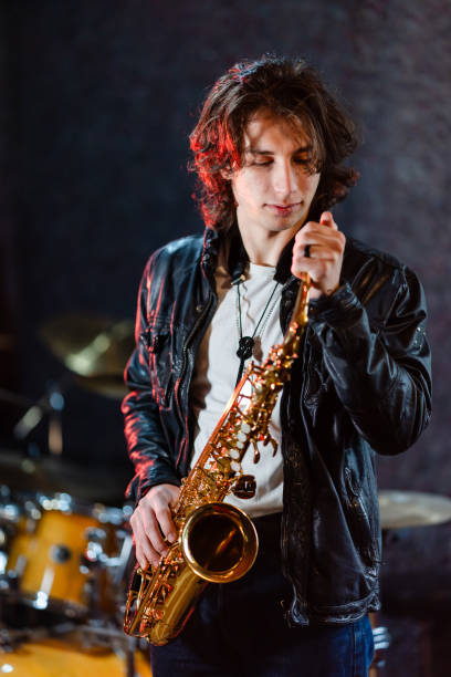 istock Young saxophone player rehearsing alone in the studio 2203003206