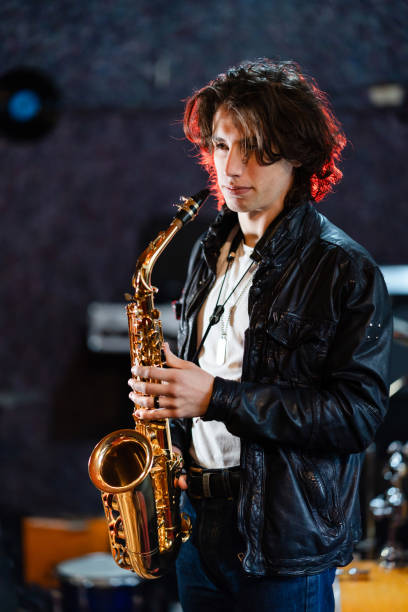 istock Young saxophone player rehearsing alone in the studio 2203003208