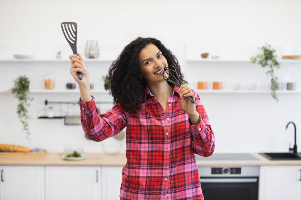 istock Woman joyfully cooking and expressing herself in modern kitchen environment 2203006512