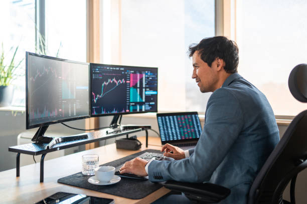 istock Asian Financial Trader Analyzing Market Data on Multiple Screens 2203007360