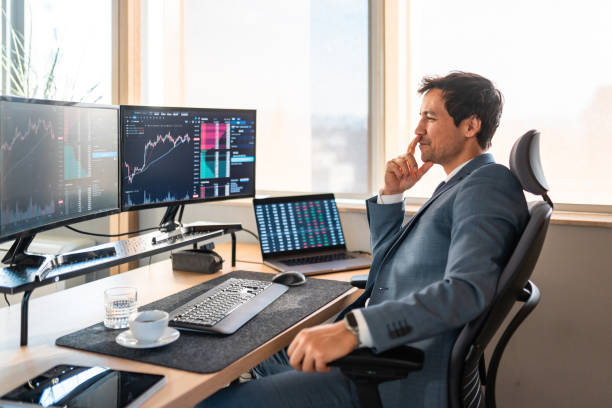 istock Asian Financial Trader Analyzing Market Data on Multiple Screens 2203007407