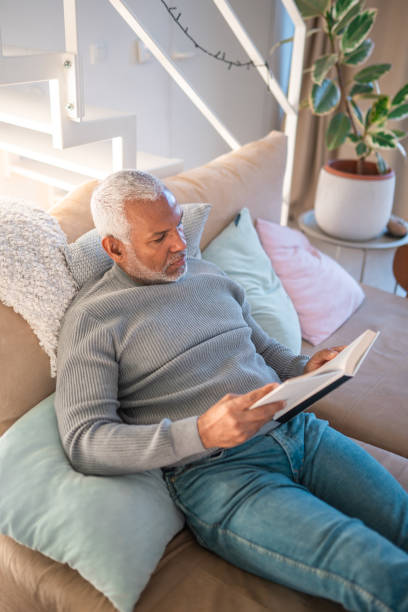 istock Mature Hispanic Male Reading in Cozy Lighting 2203008286