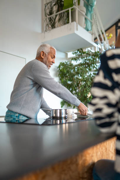 istock Elderly Hispanic Man Cooking in Bright Modern Kitchen 2203008371