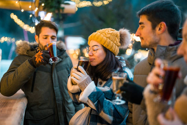 istock Young Couples Enjoy Hot Drinks In Winter Wonderland 2203010980