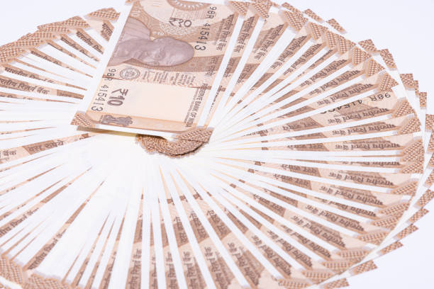 Close-up of stacked Indian rupee 100 notes isolated on white background, symbolizing small denomination cash, savings, daily expenses, and Indian financial system.