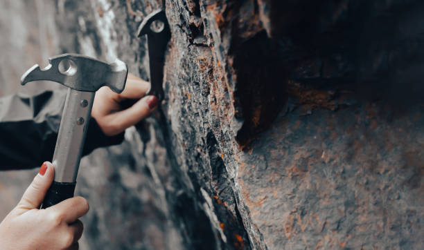 istock Female hands hold a climbing hammer and anchor. 2203017683