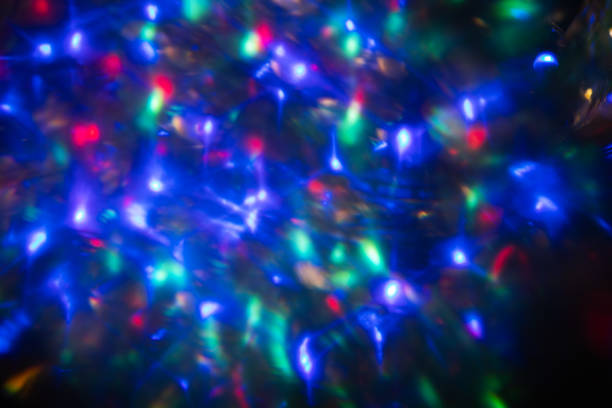 Abstract blurred colorful lens flare bokeh on black.