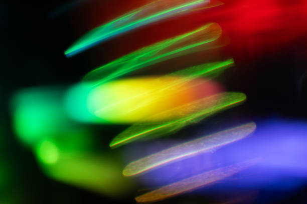 Blur neon light. Lens flare overlay. Bokeh fluorescent flash gleam. Defocused blue purple color flecks on dark black abstract background.
