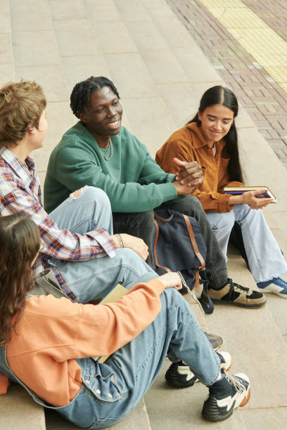 istock Smiling Friends Chatting on Urban Steps Sharing Stories 2203018639