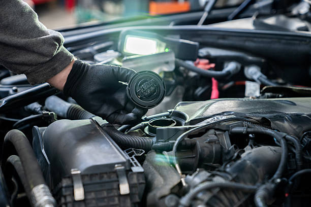istock Serviceman checks the oil level in a car engine. 2203020709