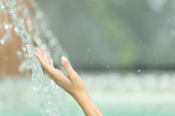 Close up of a woman hand touching water jet in spa pool