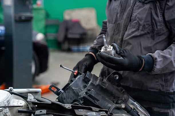 istock Serviceman repair headlight in car service. 2203020839