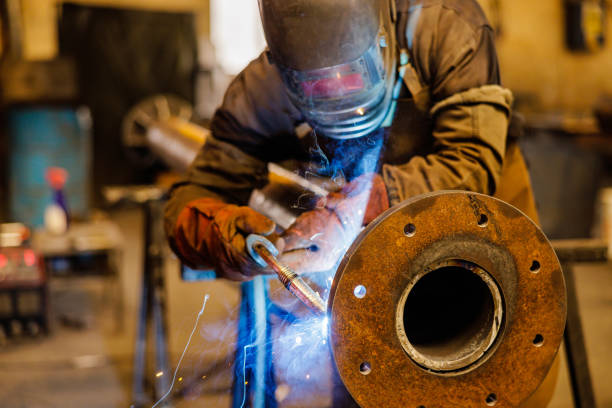 Professional industrial worker welding at the factory