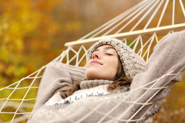istock Woman sleeping lying on hammock in nature in winter 2203027818