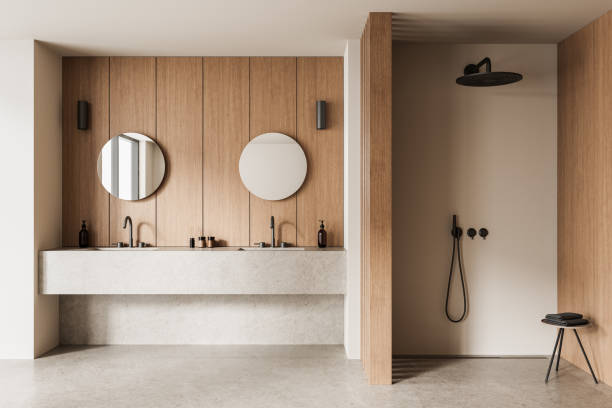 istock Minimalist bathroom interior with dual round mirrors and wood-panel walls. 3D Rendering 2203028736