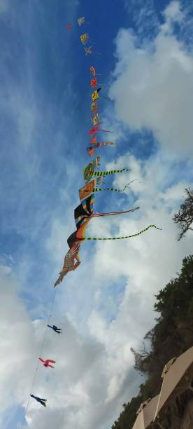 istock Colorful kites soaring in a blue sky 2203032659