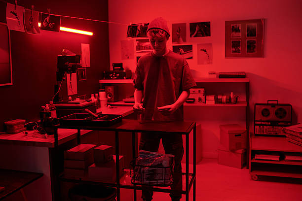 istock Man as Photographer Working in Darkroom Developing Photos 2203032709