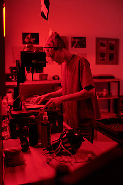 istock Photographer Working with Enlarger Equipment Developing Photo Prints in Darkroom 2203032731